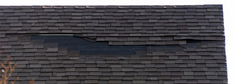 asphalt shingle roof with wind damage, missing shingles