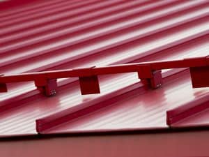 a close-up of a snow guard attached to a standing seam metal roof